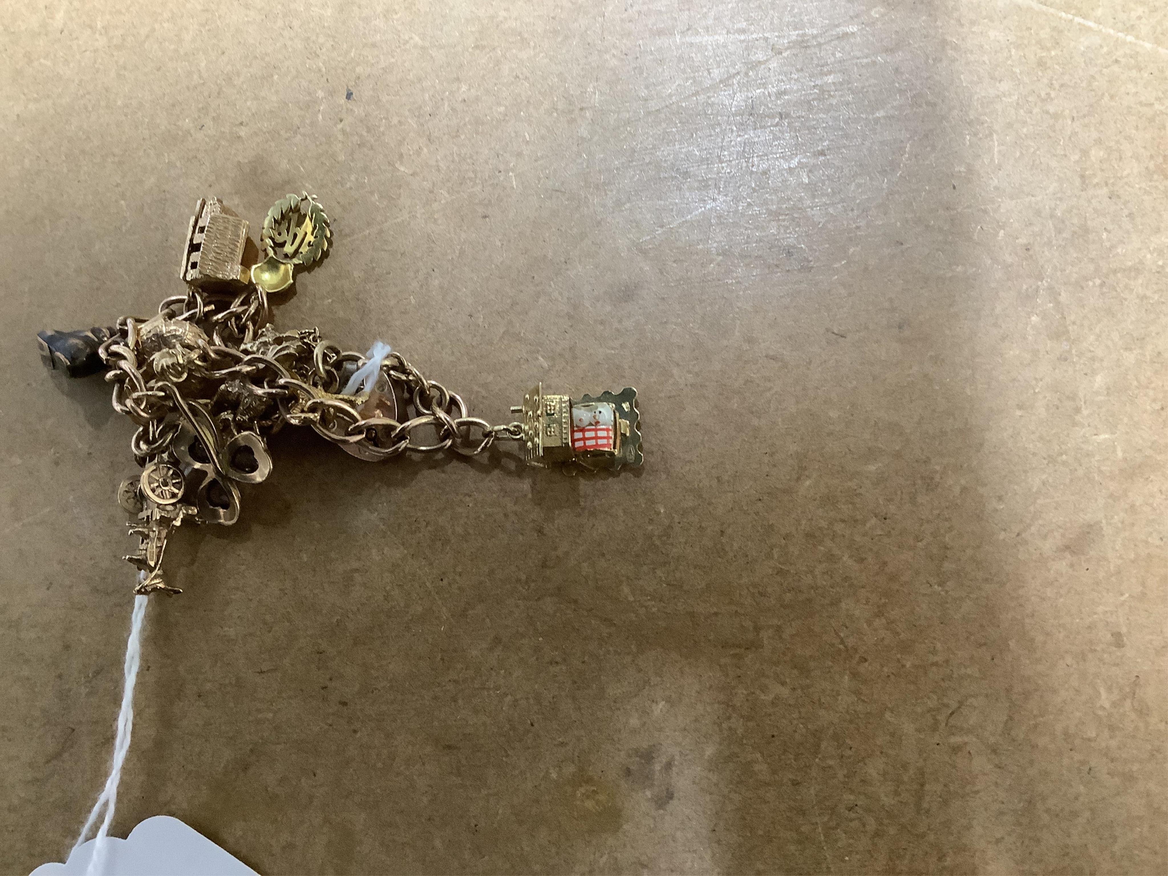 A 9ct gold curb link charm bracelet, hung with ten assorted 9ct gold and yellow metal charms including enamelled R.A.F. charm and a pixie on a toadstool, approximately 14cm, gross weight 31 grams.